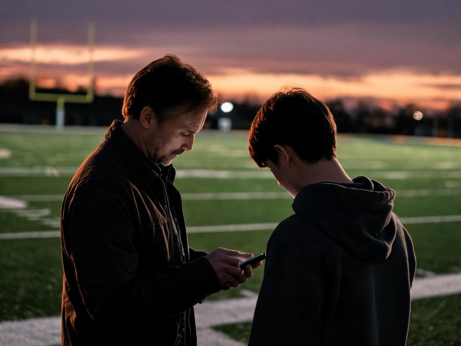 A parent and athlete look at a result together